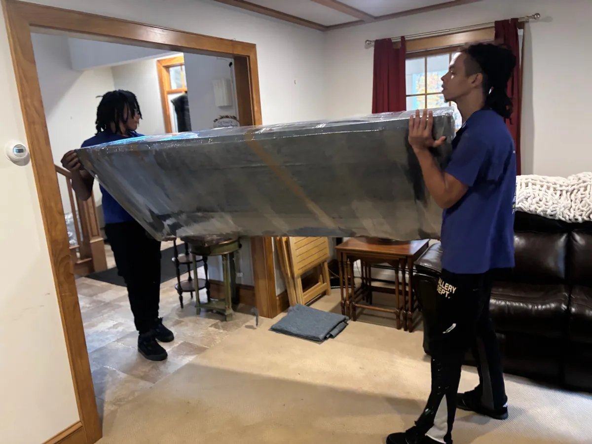 EAM Moving crew carrying a wrapped corner hutch during a Meredith, NH move